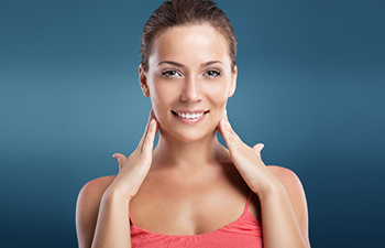 smiling woman touching her cheeks with her hands