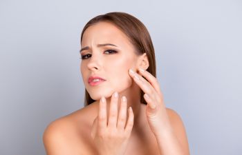 Woman Looking at Her Acne in the Mirror