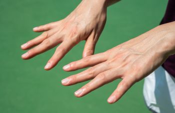 Person looking at their nails hands and nails.